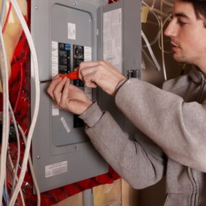 man with a screwdriver next to energy panel