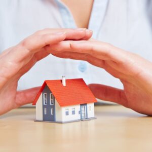 hands over a toy home