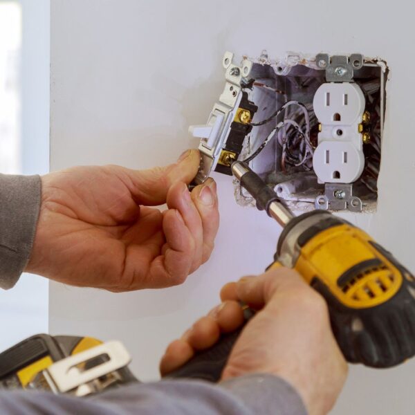 person installing electrical outlet