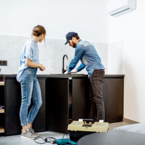 Man and woman fix sink