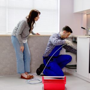 Plumber trying to remove a clog from a sink pipe.