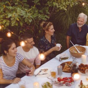 Family and friends enjoying dinner under string lights