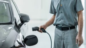 man plugging in garage electric vehicle charger to car