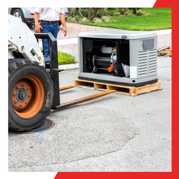 A light gray home standby generator with its side panel open, sitting on a wooden pallet next to a bobcat forklift on a paved surface, indicating installation or delivery.