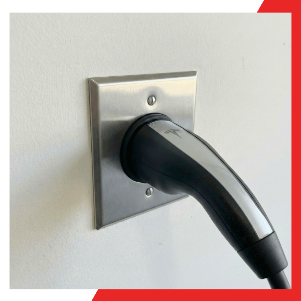 Professional 240V outlet for electric car with a Tesla mobile connector plugged in and ready for use.