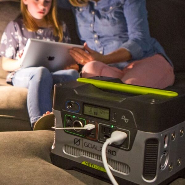 Mother and daughter reading on a ipad connected to a Goal Zero Yeti portable generator.